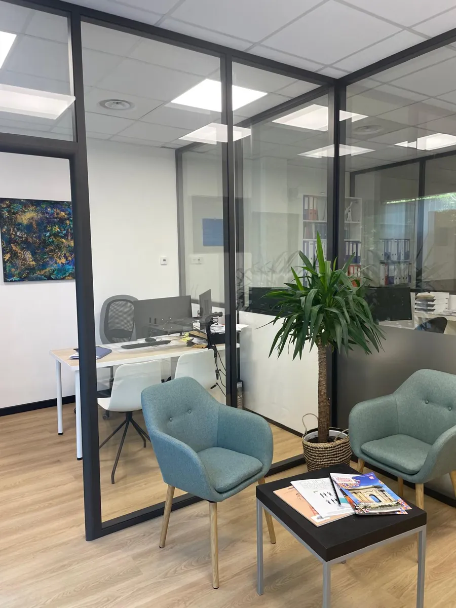 Espace d'accueil du cabinet MCeco avec fauteuils et bureaux vitrés
